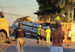 Carreta tomba na BR-101 e espalha carga de tubos pela rodovia em Campos
